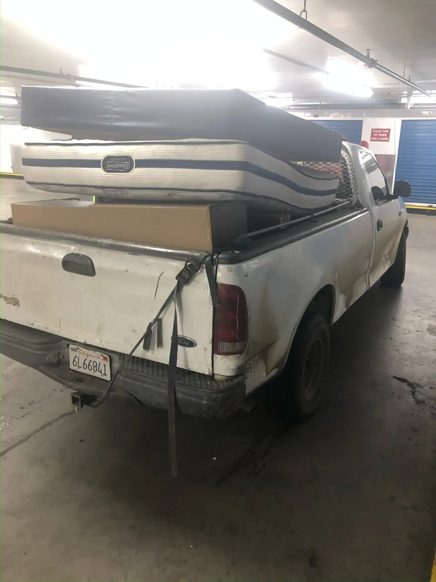 a white truck with mattresses in the back